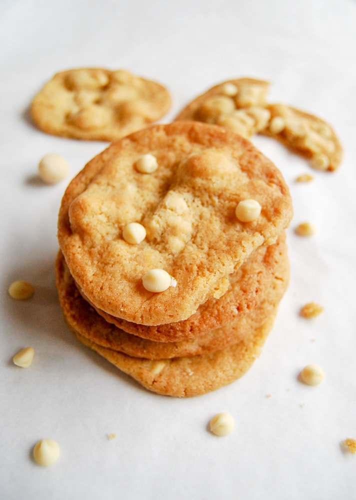 A stack of white chocolate and macadamia nut cookies on a white background.