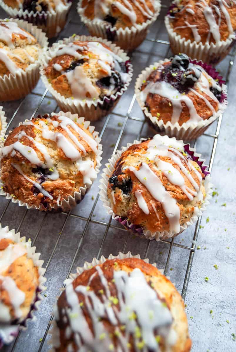 An overhead picture of lemon poppy seed muffins with an icing glaze on a silver wire rack