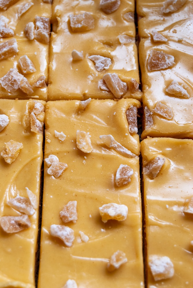 A close up of slices of ginger crunch bars sprinkled with crystallised ginger