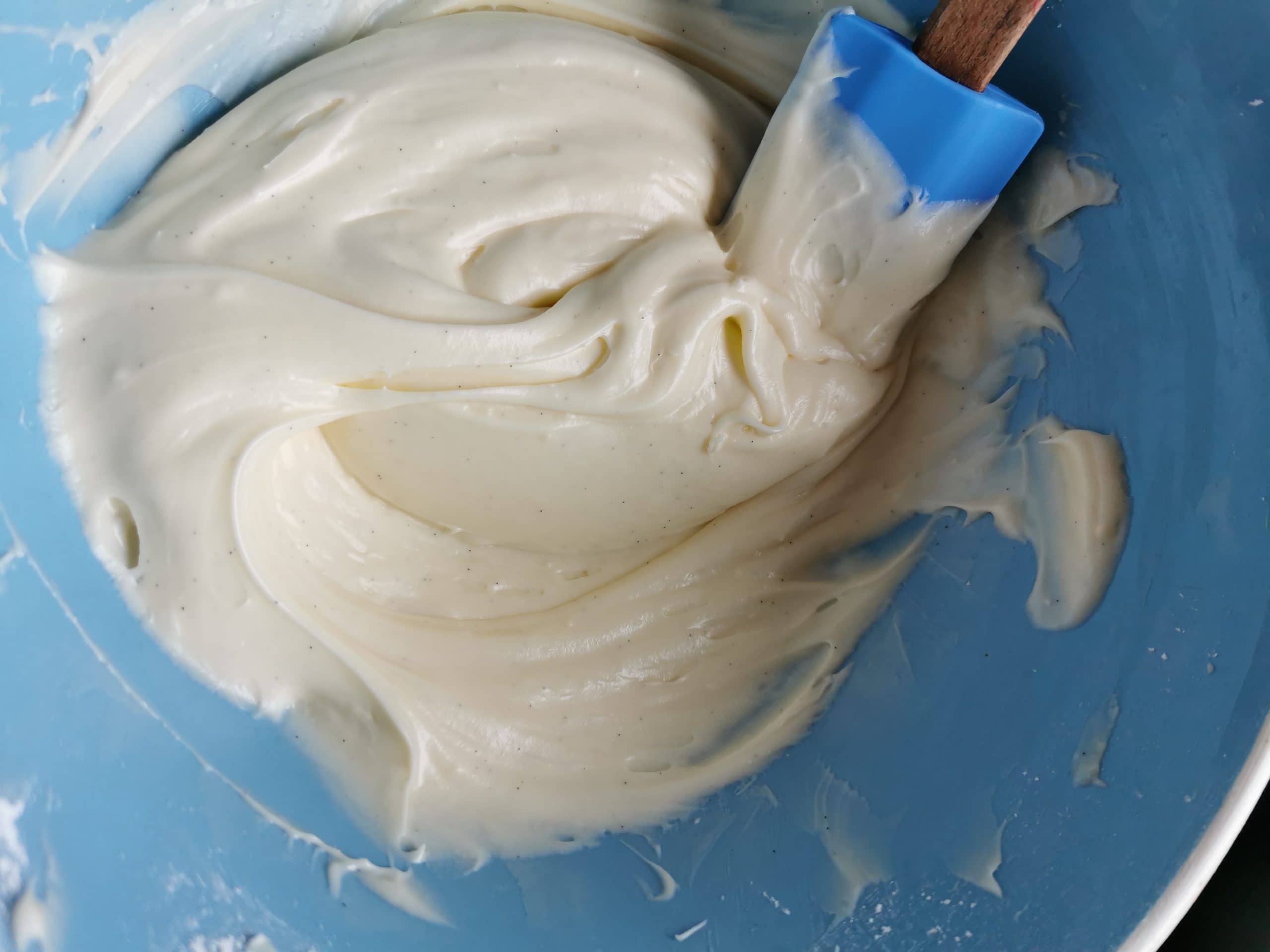 A blue and white bowl of cream cheese frosting