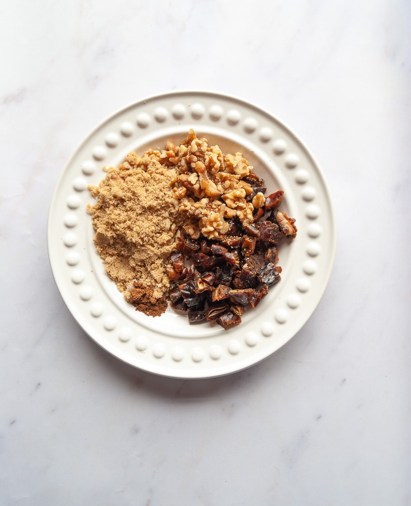 A plate of brown sugar, walnuts and dates.