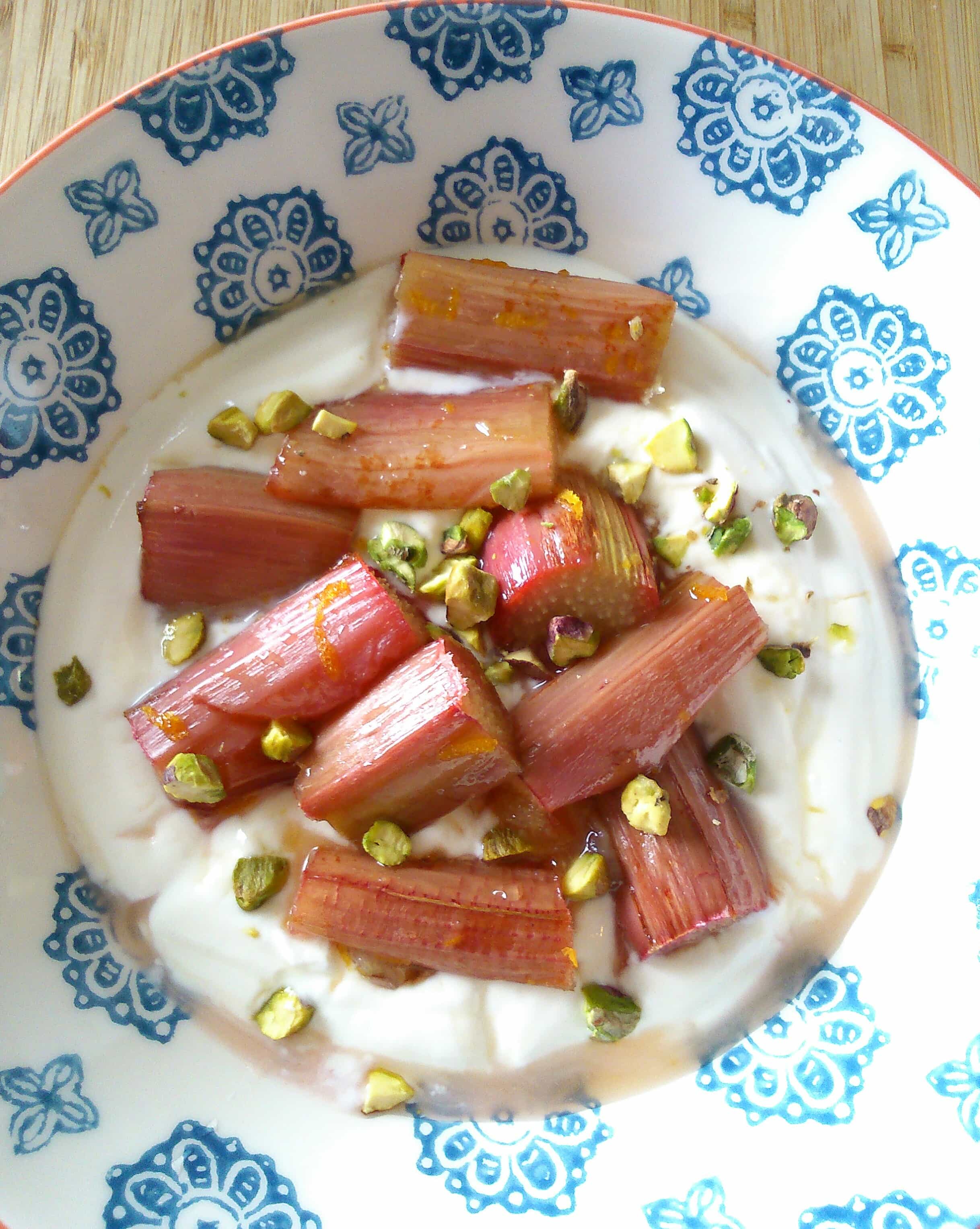 a blue patterned bowl with roasted rhubarb, chopped pistachio nuts and greek yoghurt