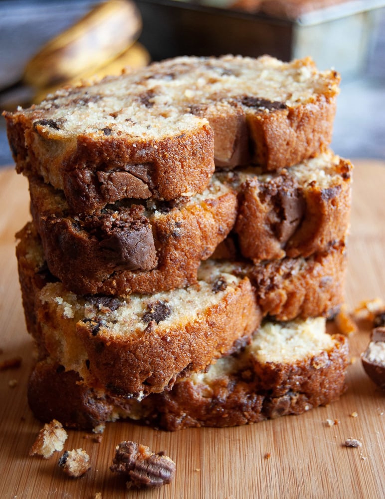 A stack of peanut butter cup banana bread slices on a wooden board.