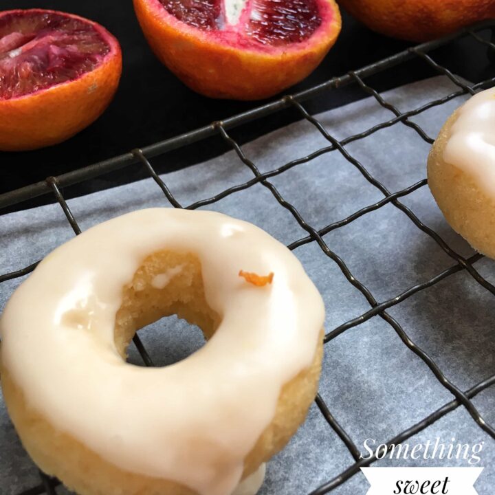 A close up picture of a mini baked dounut covered in an orange glaze