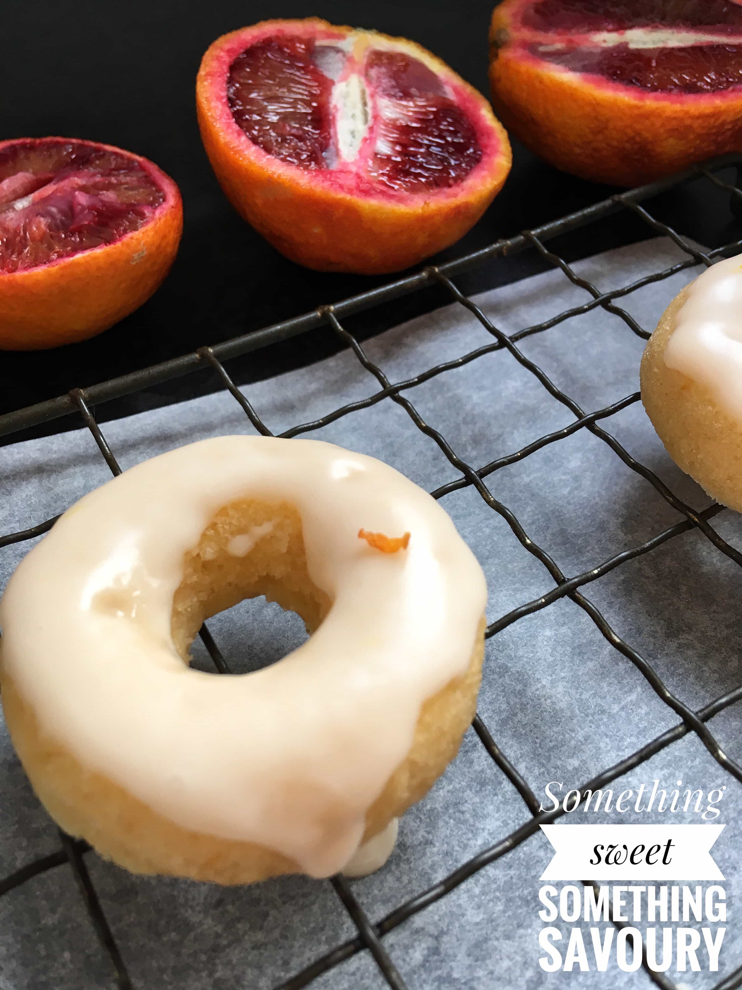 A close up picture of a mini baked dounut covered in an orange glaze