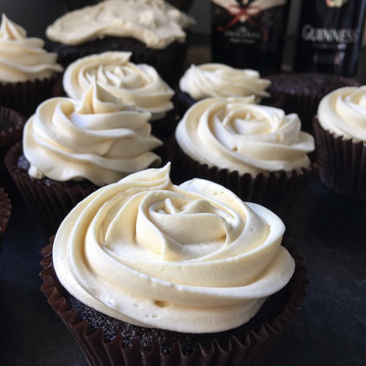 A row of chocolate Guinness cupcakes with Baileys buttercream. The dark chocolate cupcakes are topped with a rose swirl of Baileys buttercream
