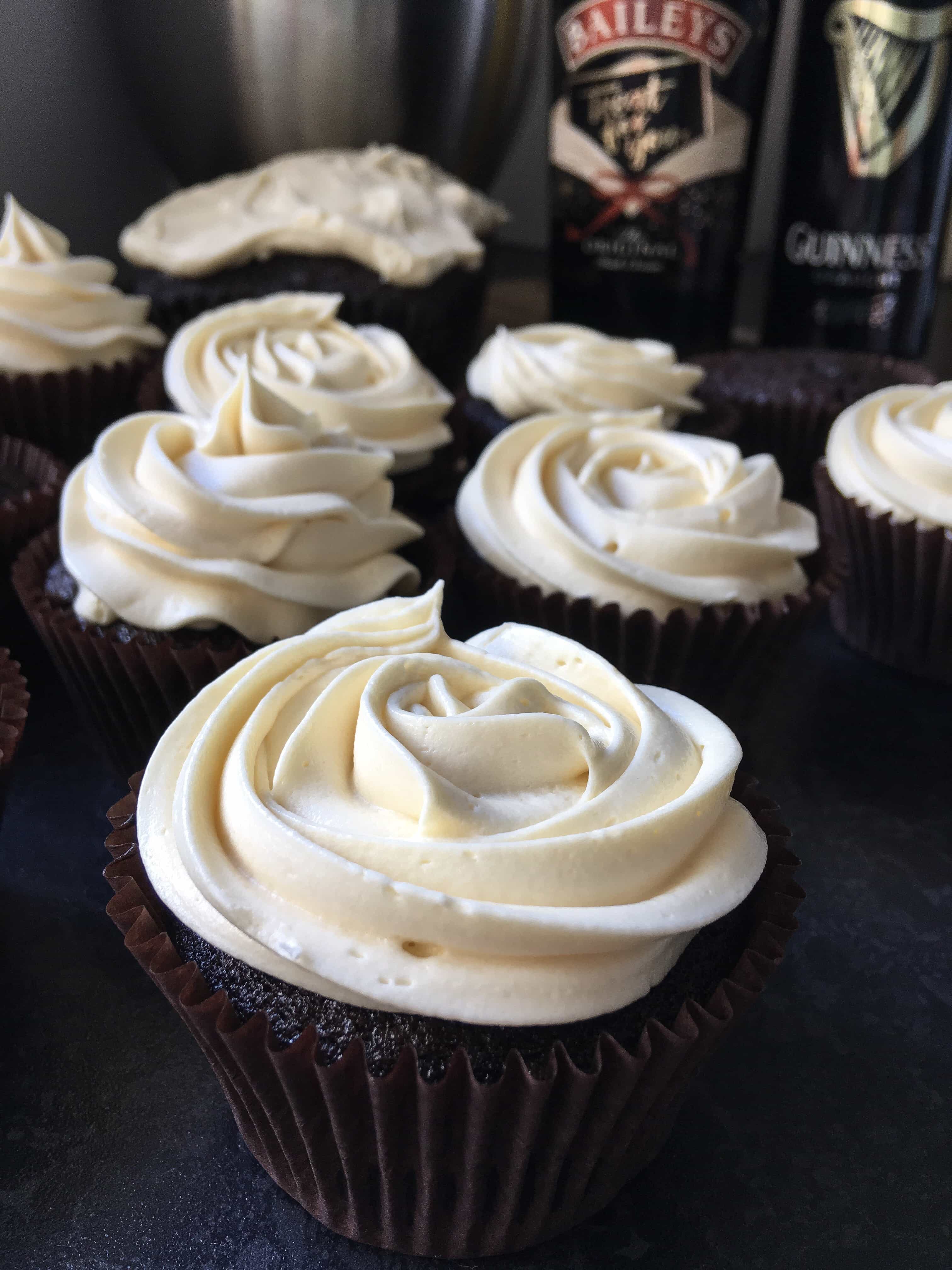 A close up photo of dark chocolate cupcakes topped with a rose style swirl of Baileys cream frosting.