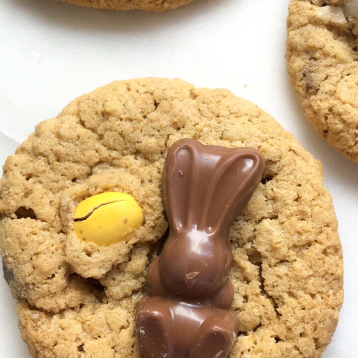 A picture of cookies topped with mini Easter eggs and chocolate bunnies on a white backdrop