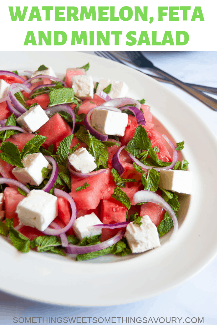watermelon, feta and mint salad with red onion slices on a white platter