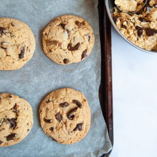 Four chocolate pretzel cookies on a baking tray