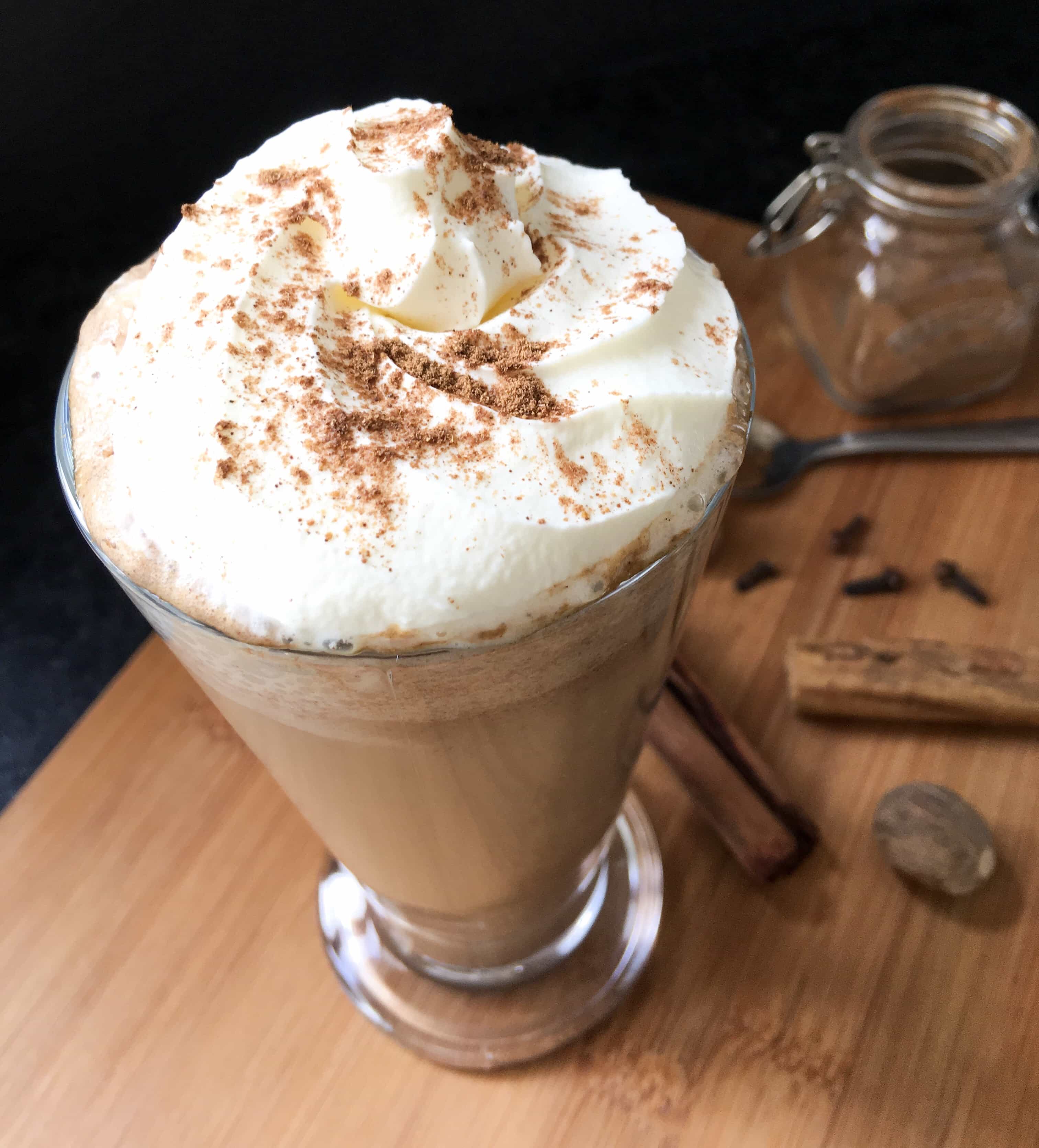 A tall glass of homemade pumpkin spice latte, spinkled with cinnamon