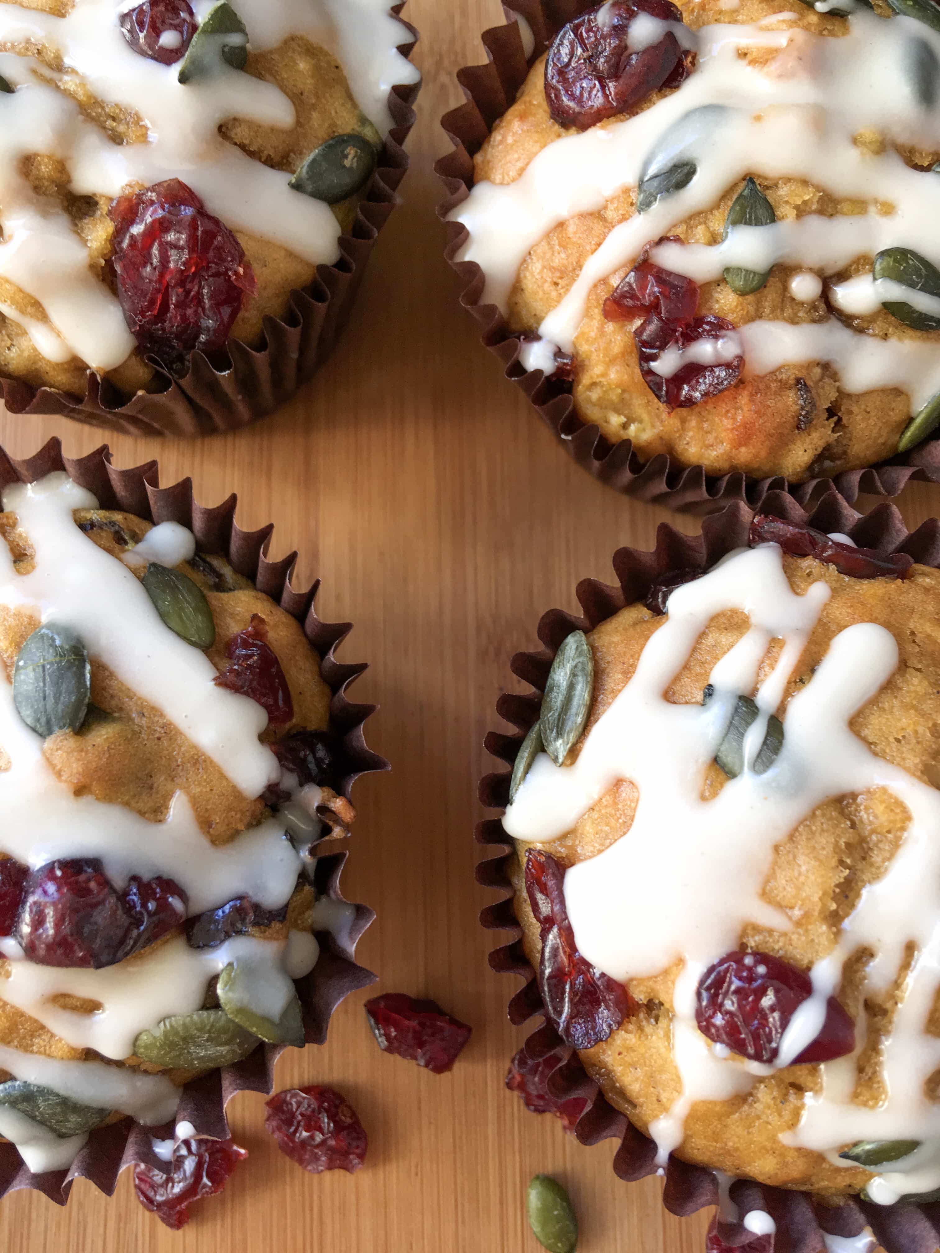 A close up flat lay photo of pumpkin muffins with a maple icing drizzle