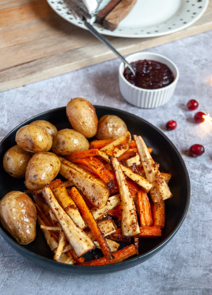 A black bowl of honey mustard Roasted parsnips and carrots 