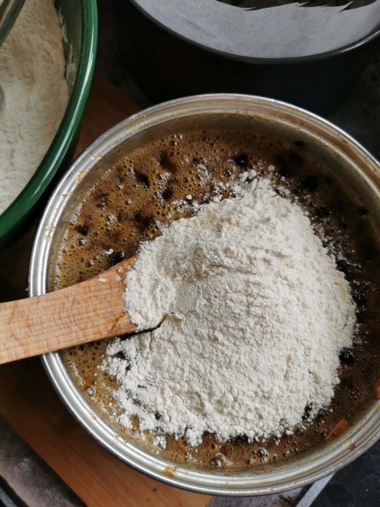 Flour being stirred into fruit cake batter