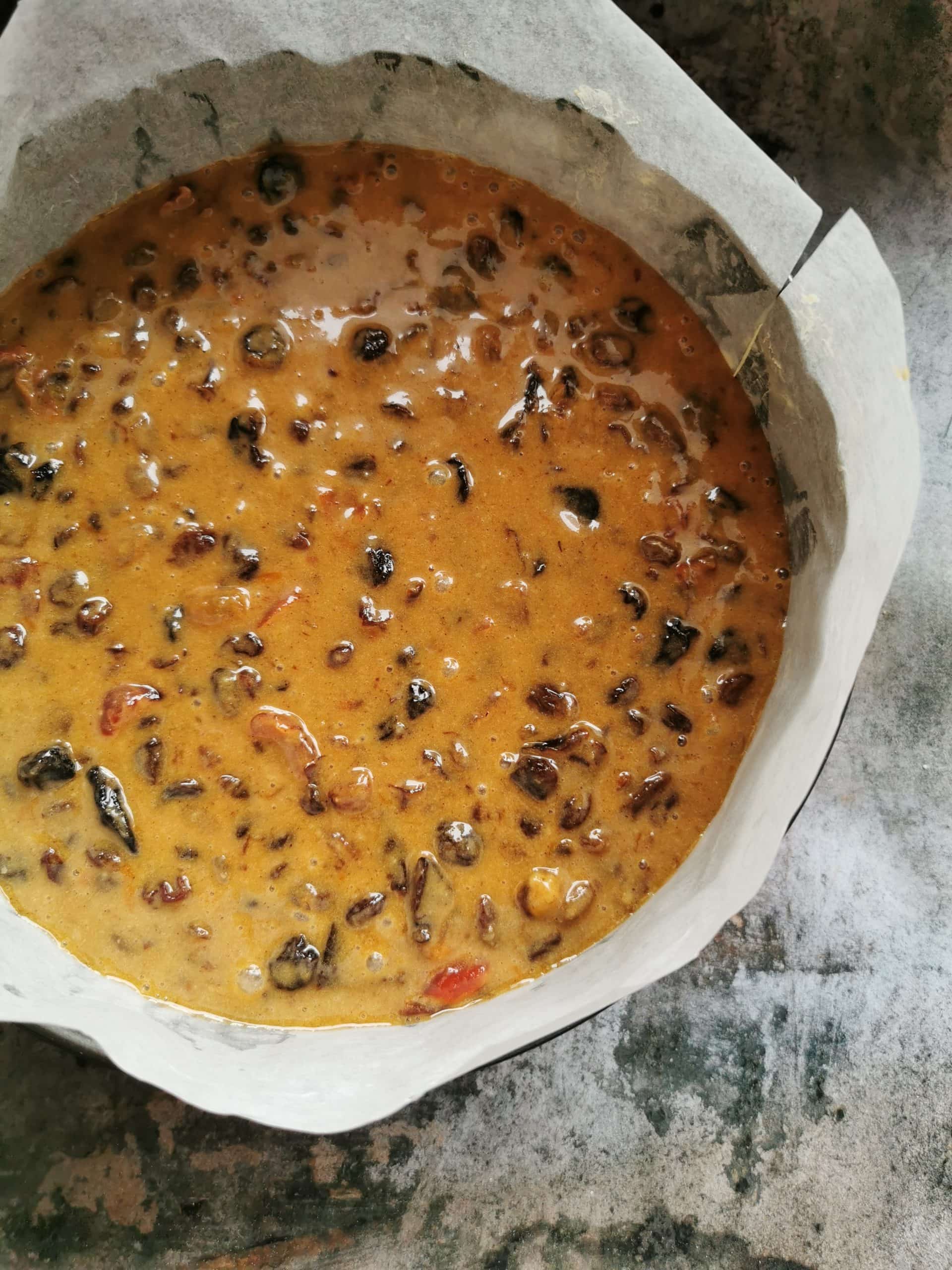 An unbaked fruit cake in a round cake tin 