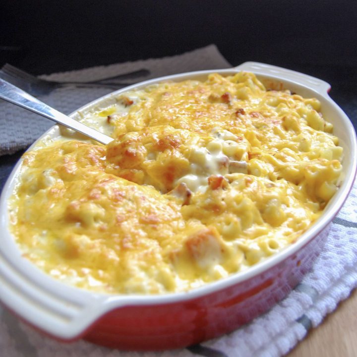 A red Le Crueset casserole dish with pumpkin macaroni cheese