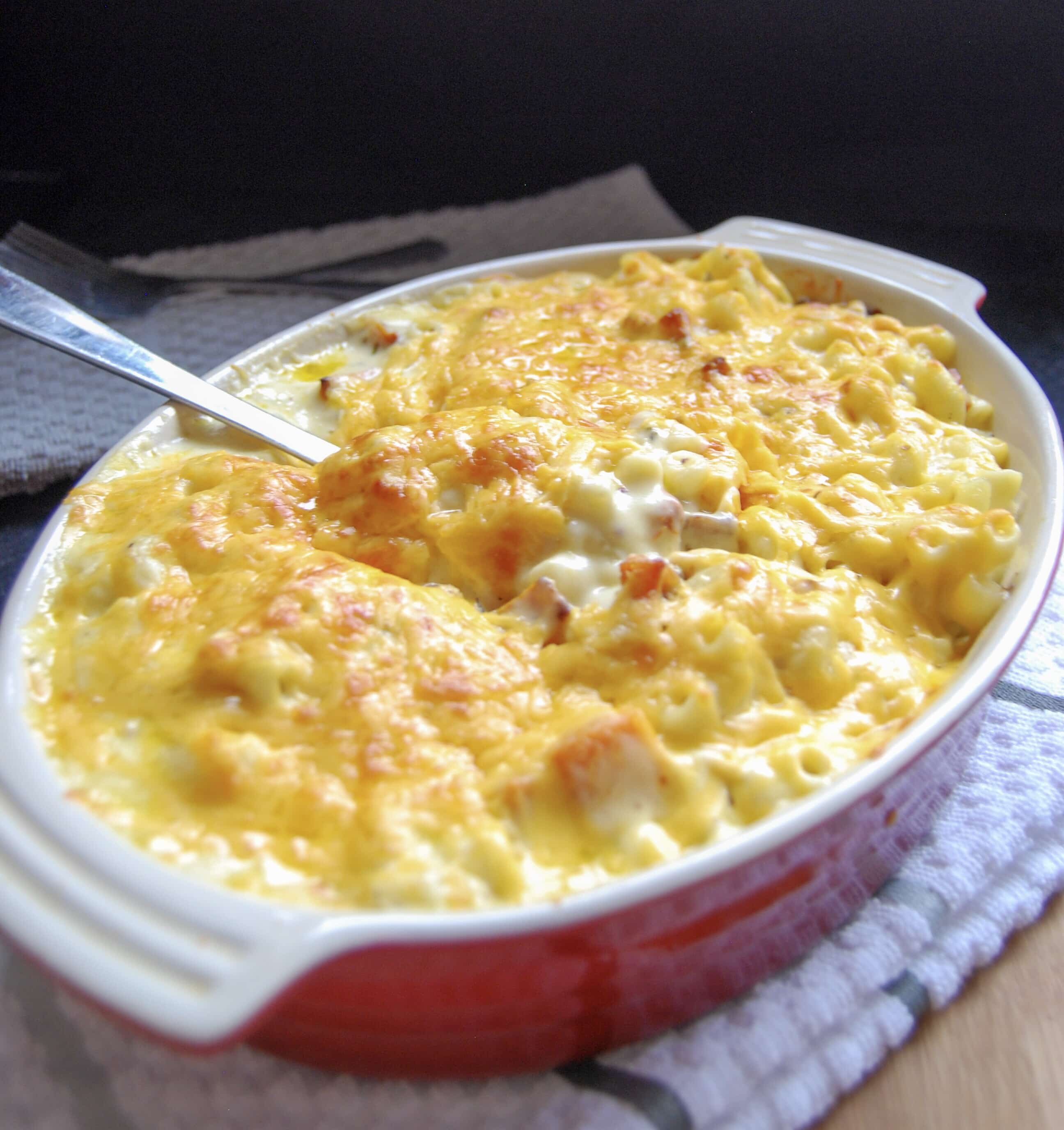 A red Le Crueset casserole dish with pumpkin macaroni cheese