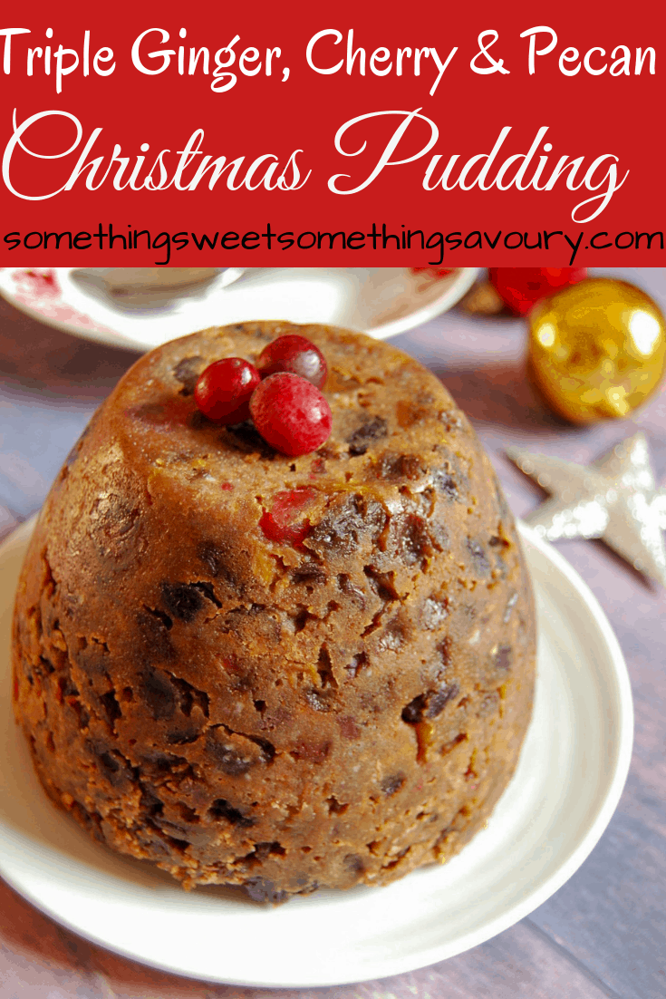 a pinterest image with the words "triple ginger, cherry and pecan Christmas pudding" in white text on a red background with a photo of a Christmas pudding topped with fresh cranberries on a white plate.  Gold and red baubles and a silver star decoration can be seen in the background.