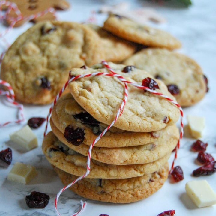 a stack of white chocolate and cranberry cookies tied with red and white string.