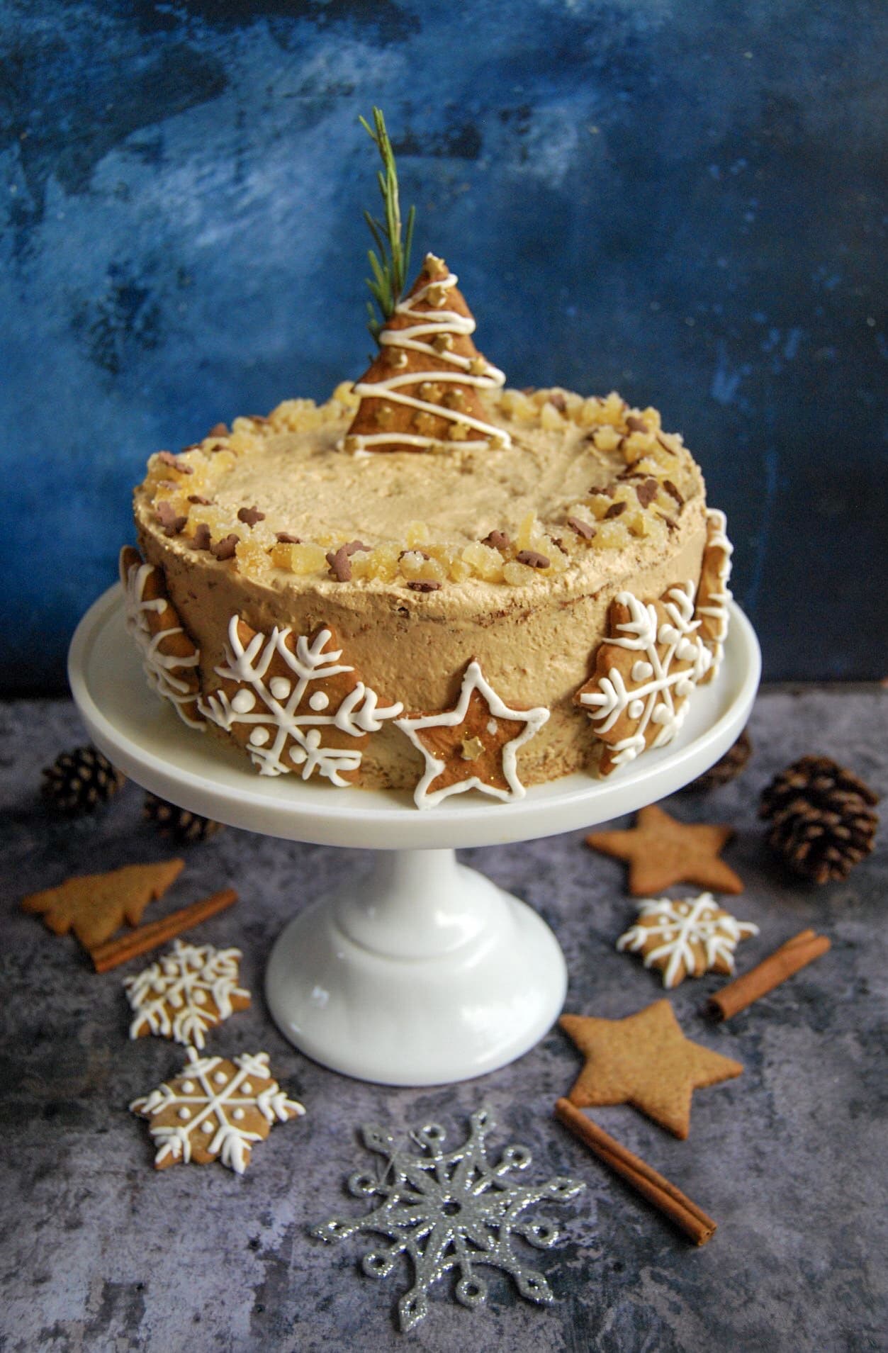 A gingerbread latte cake iced with Biscoff Buttercream and decorated with iced gingerbread cookies. 