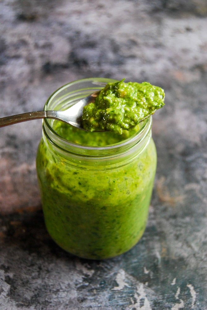 A jar of wild garlic pesto on a textured grey background 