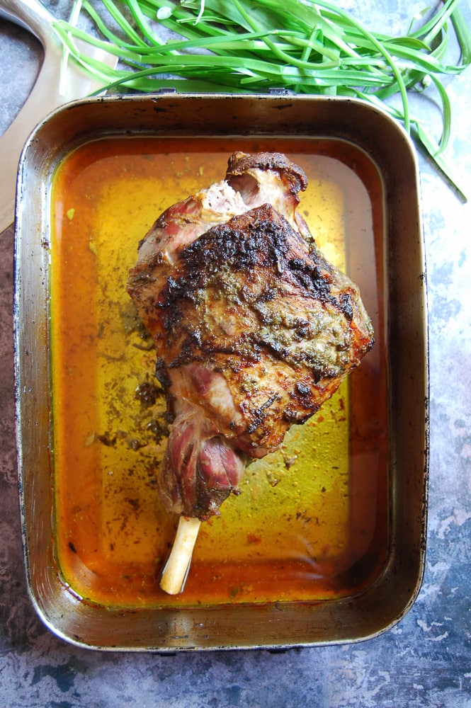 A leg of cooked lamb in a roasting tin. 