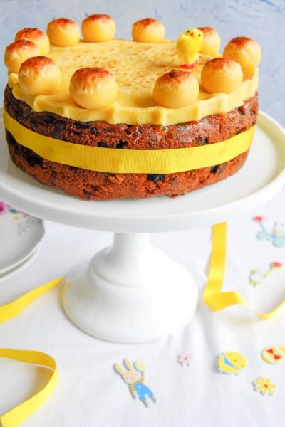 A slice of Easter Simnel cake topped with a marzipan ball on a floral plate.