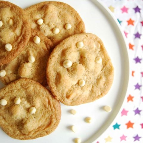 A flatlay photo of a plate of white chocolate macadamia nut cookies.