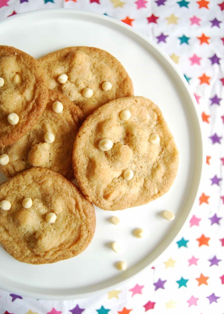 A flatlay photo of a plate of white chocolate macadamia nut cookies.