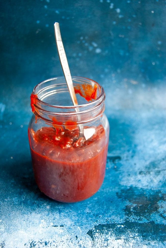 A jar of Easy BBQ Sauce on a blue background