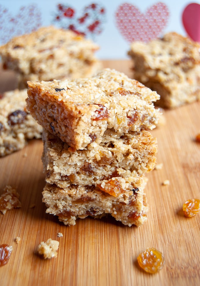 A stack of Fruity Flapjacks studded with raisins, sultanas and chopped apricots on a wooden board