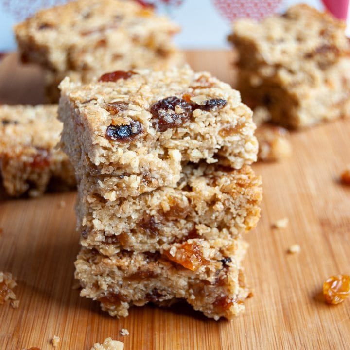 A stack of Fruity Flapjacks studded with raisins, sultanas and chopped apricots on a wooden board