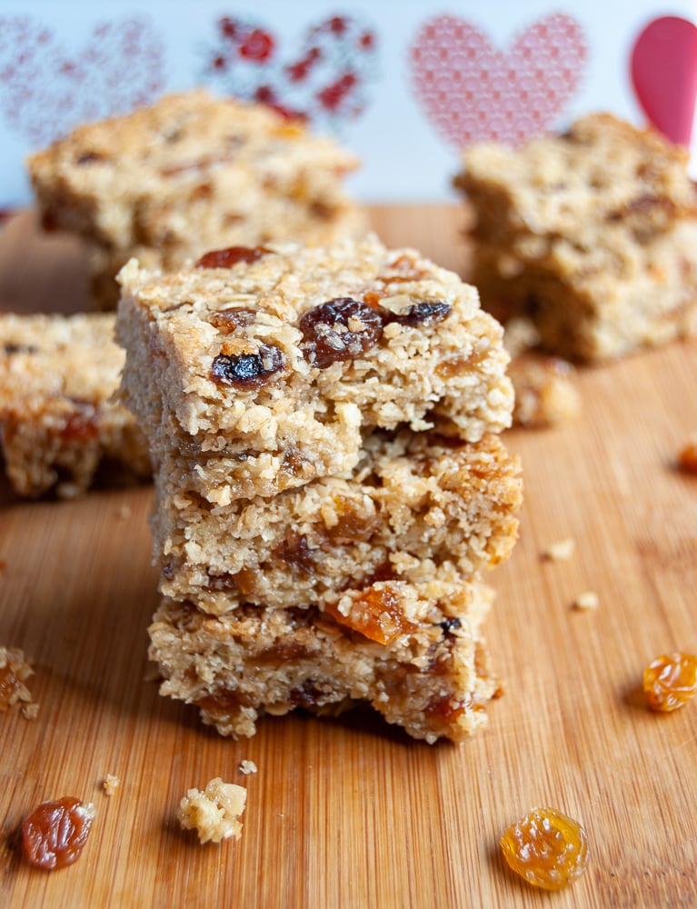 A stack of Fruity Flapjacks studded with raisins, sultanas and chopped apricots on a wooden board