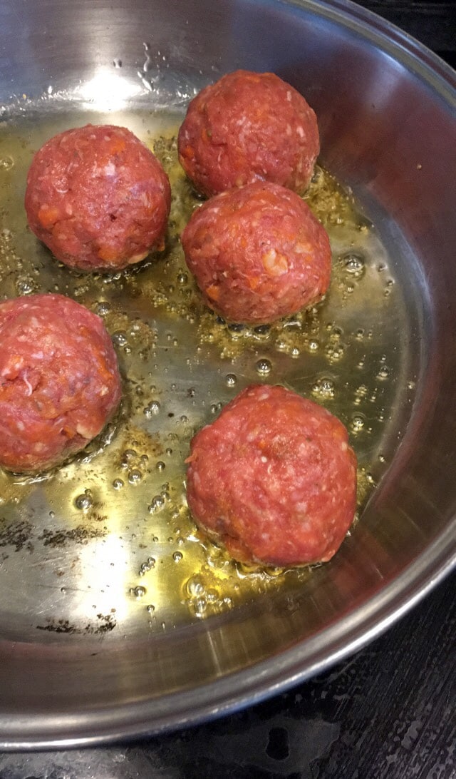 beef meatballs cooking in a frying pan