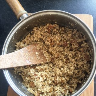 A saucepan of oats, butter, honey and dried fruit for making fruity flapjacks