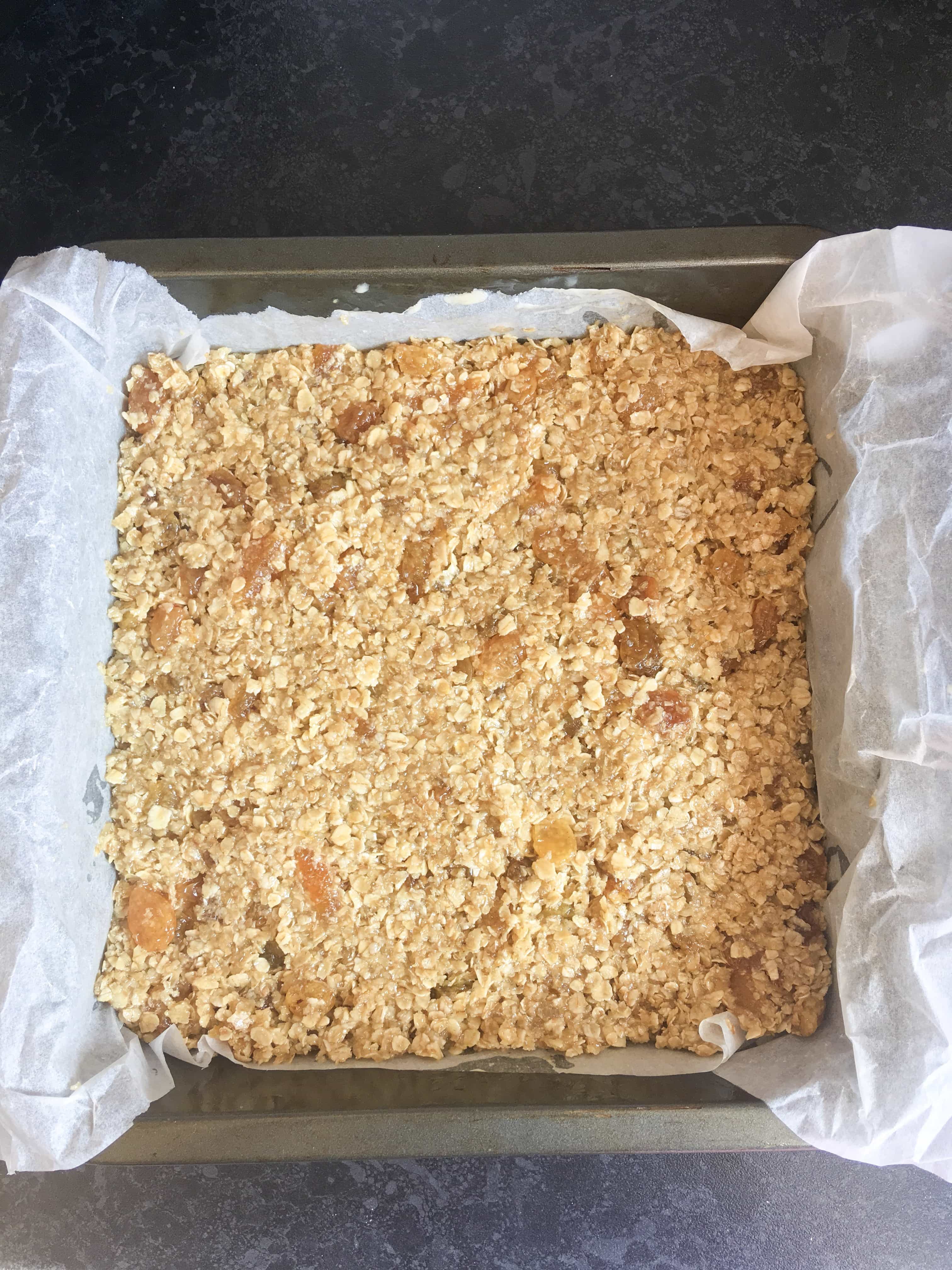 A square tin of unbaked fruity flapjacks