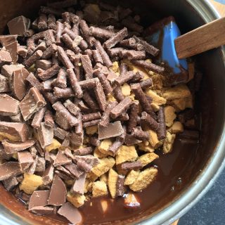 A pan of chocolate, butter, golden syrup, terry's chocolate orange and matchmakers for making a chocolate orange traybake