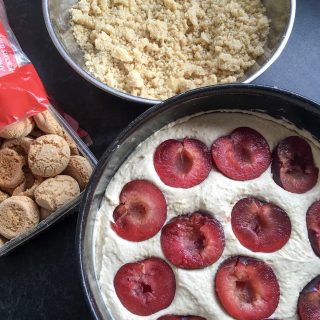 An unbaked Plum Amaretti Crumble cake - an almond sponge topped with ripe halved plums