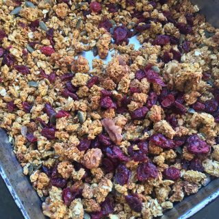 A tray of pumpkin spice granola with dried cranberries