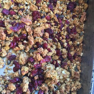 A tray of freshly made pumpkin spice granola with dried cranberries, walnuts and pumpkin seeds