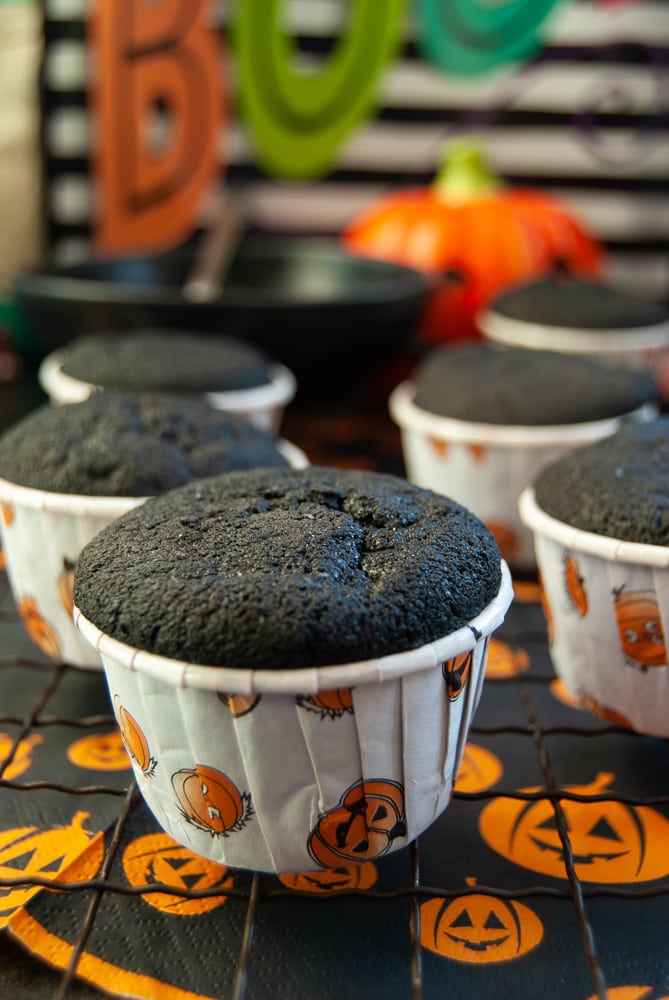 Black Velvet Cupcakes on a wire rack and an orange pumpkin tablecloth