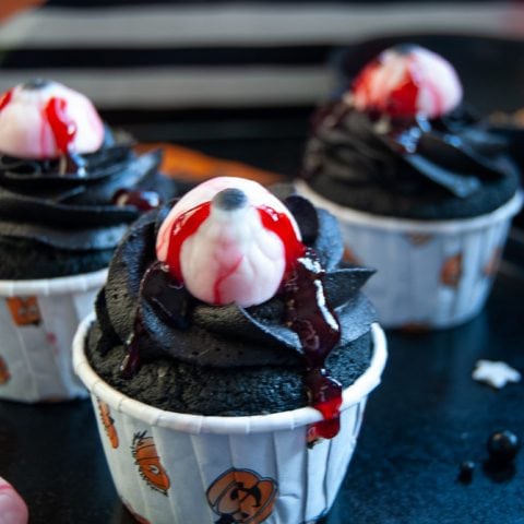 black velvet eyeball cupcakes topped with a candy eyeball and raspberry jam to look like blood.