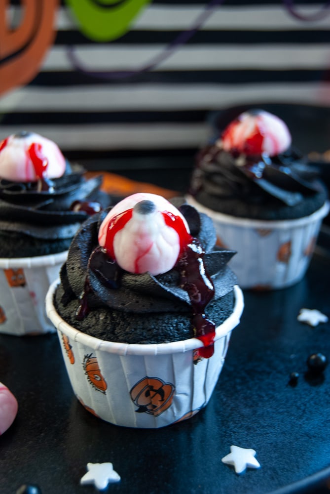 black velvet eyeball cupcakes topped with a candy eyeball and raspberry jam to look like blood. 