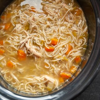 A crock pot of hot chicken noodle soup