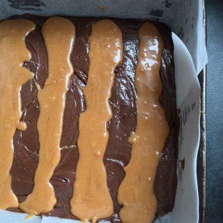 A tin of unbaked brownie batter with salted caramel