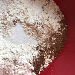 A bowl of flour, raising agents, brown sugar and spices for making treacle scones