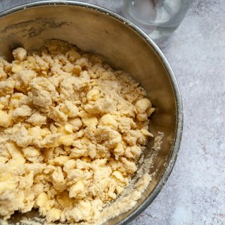 a bowl of butter rubbed into flour for making pie dough