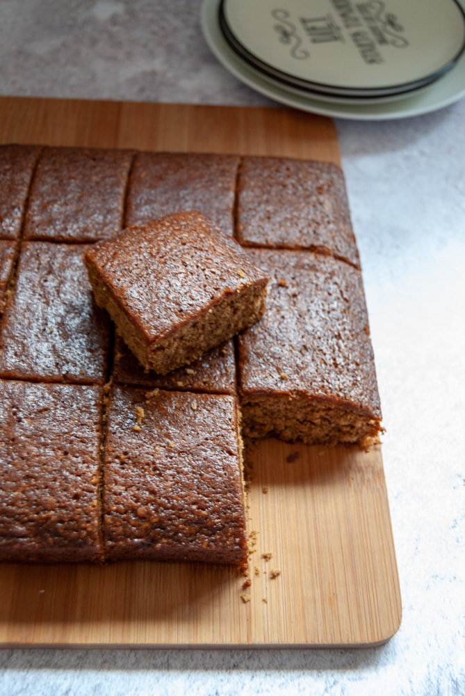 A wooden board with squares of ginger parkin cake.