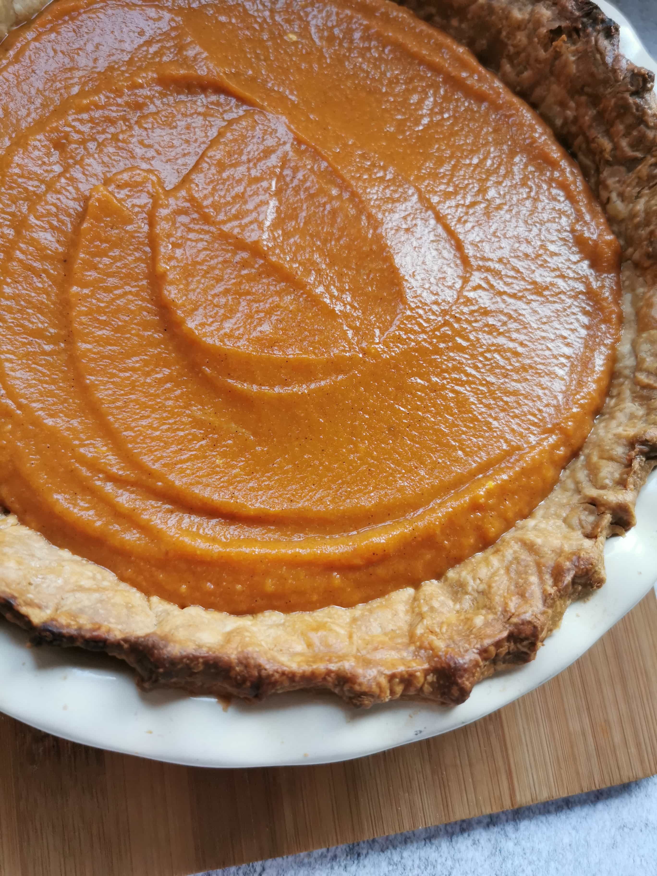 A close up picture of a pumpkin pie ready for the oven 