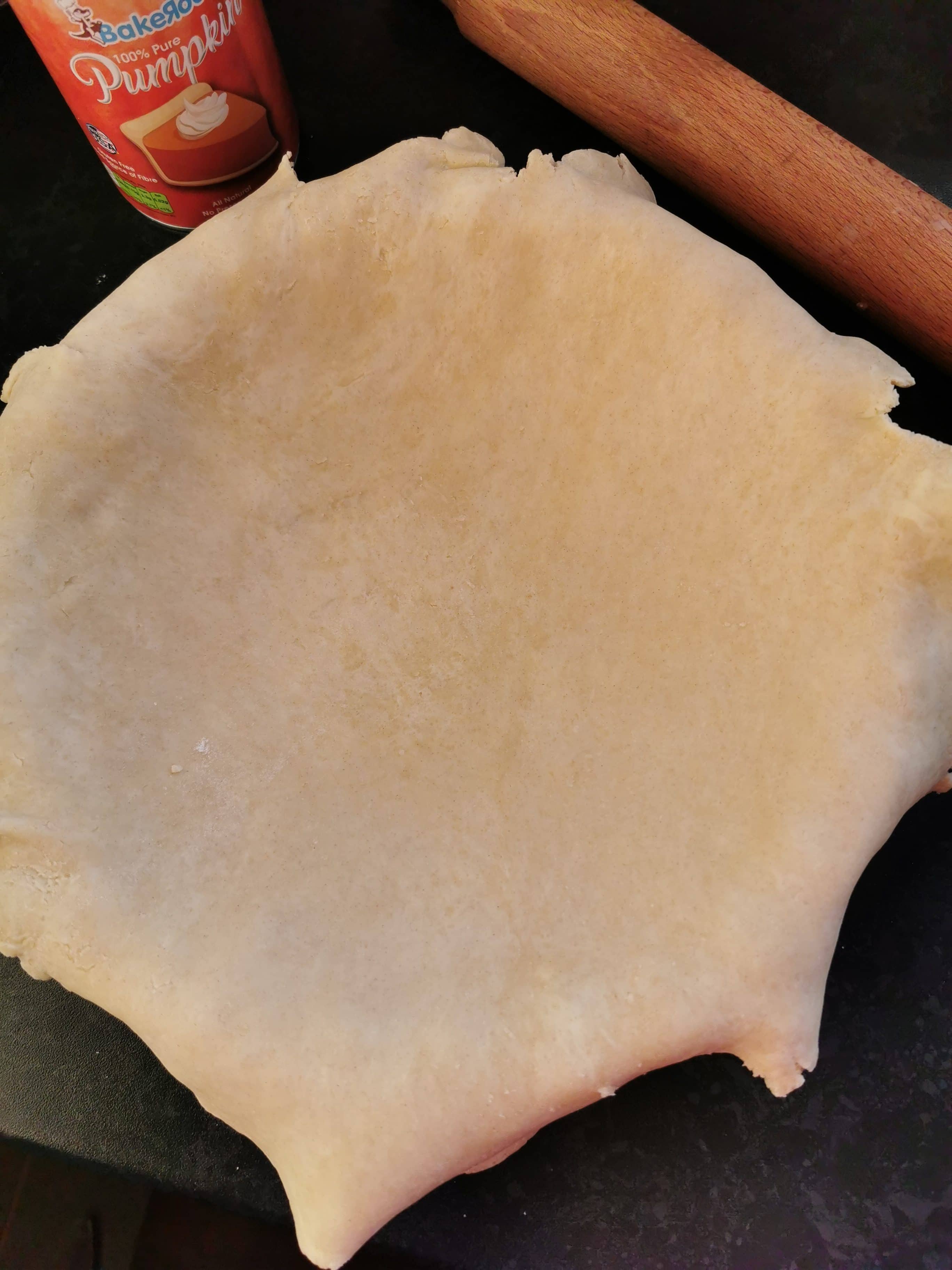 Pie dough being placed in a pie dish.